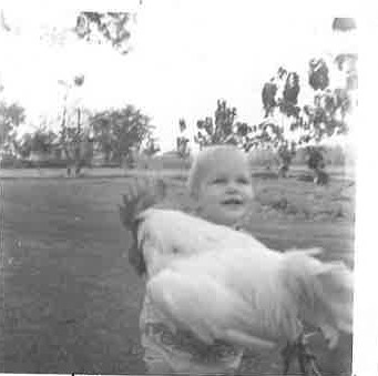Sue as a baby with a chicken