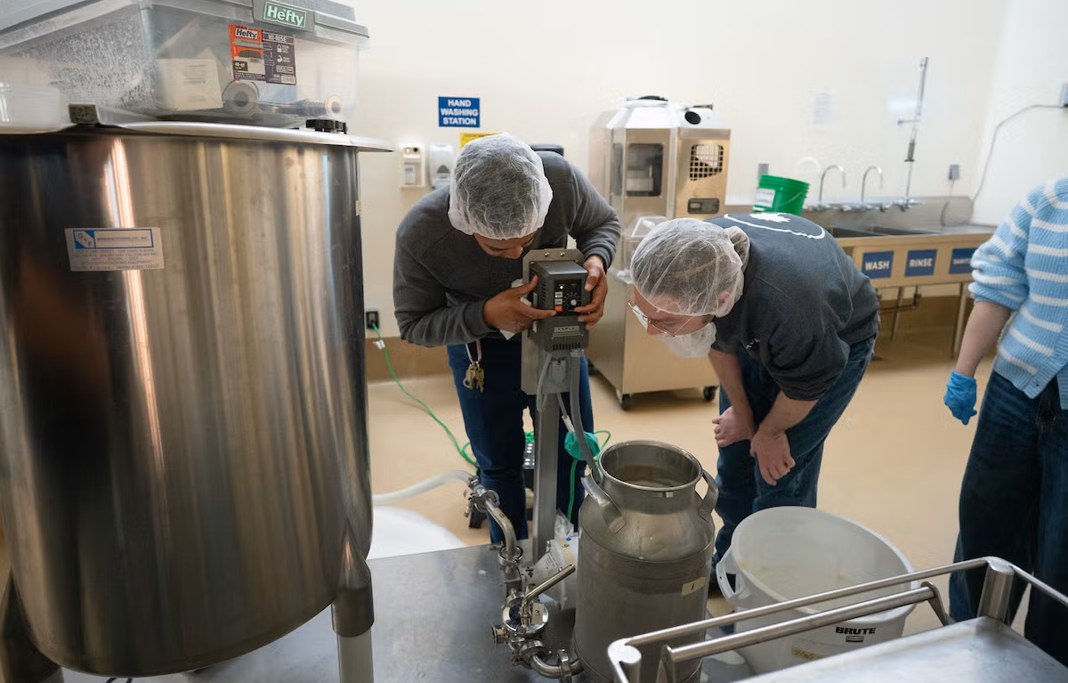 Amy Fletcher and Reid Waterman use the ice cream maker in the FST food pilot plant