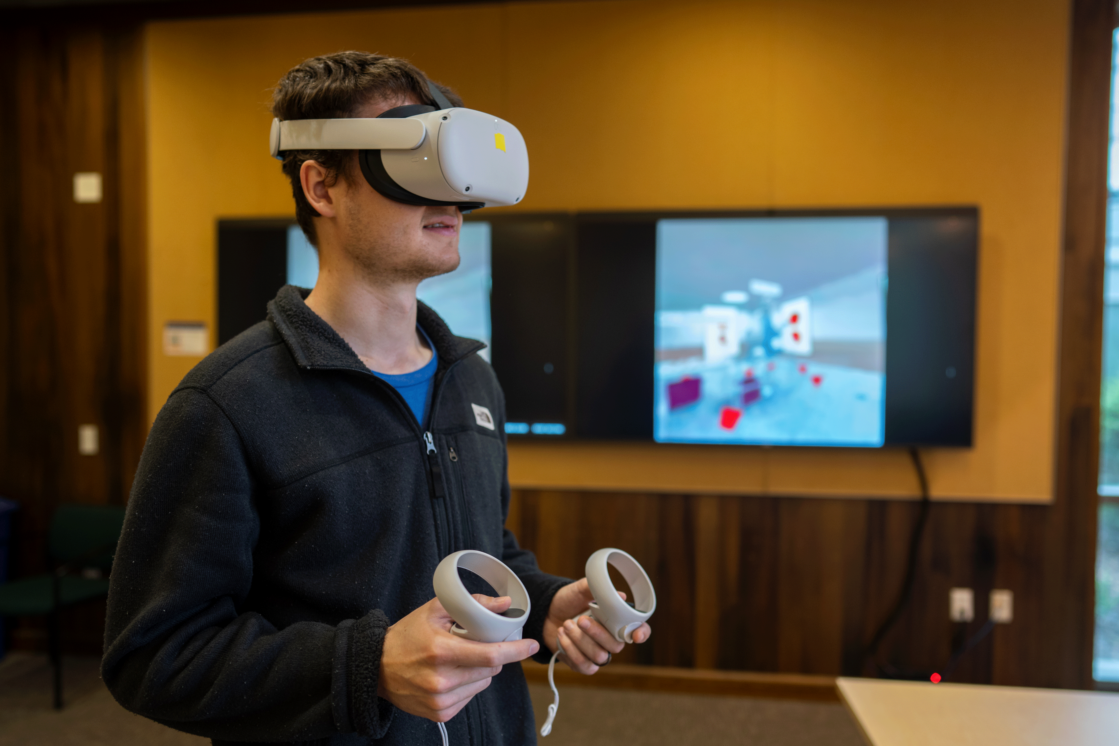 image of Shayne Morrissey wearing VR goggles with screen in background