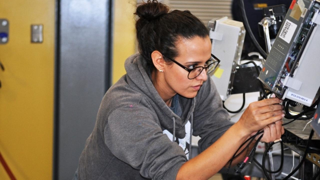 A student in the Winemaking lab class adjusts a fermenter. student in lab