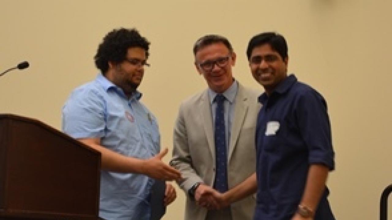Postdoc Bipin Kumar (right) receives his award.