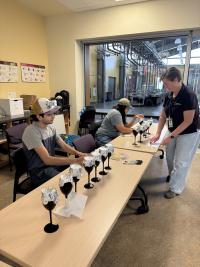 Students try to detect aromas in black wine glasses